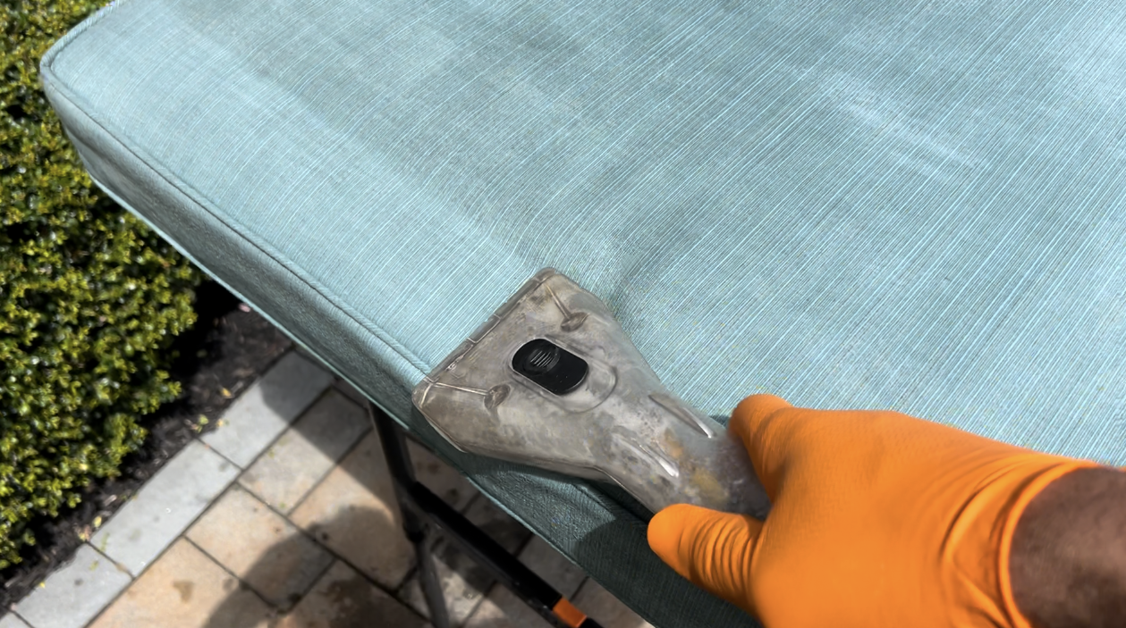 cleaning upholstery, vacuum suction removing dirt from cushion